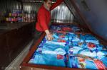 Foto: Bożena Jarząbek, kierownik schroniska pokazuje skrzynie pełne karmy